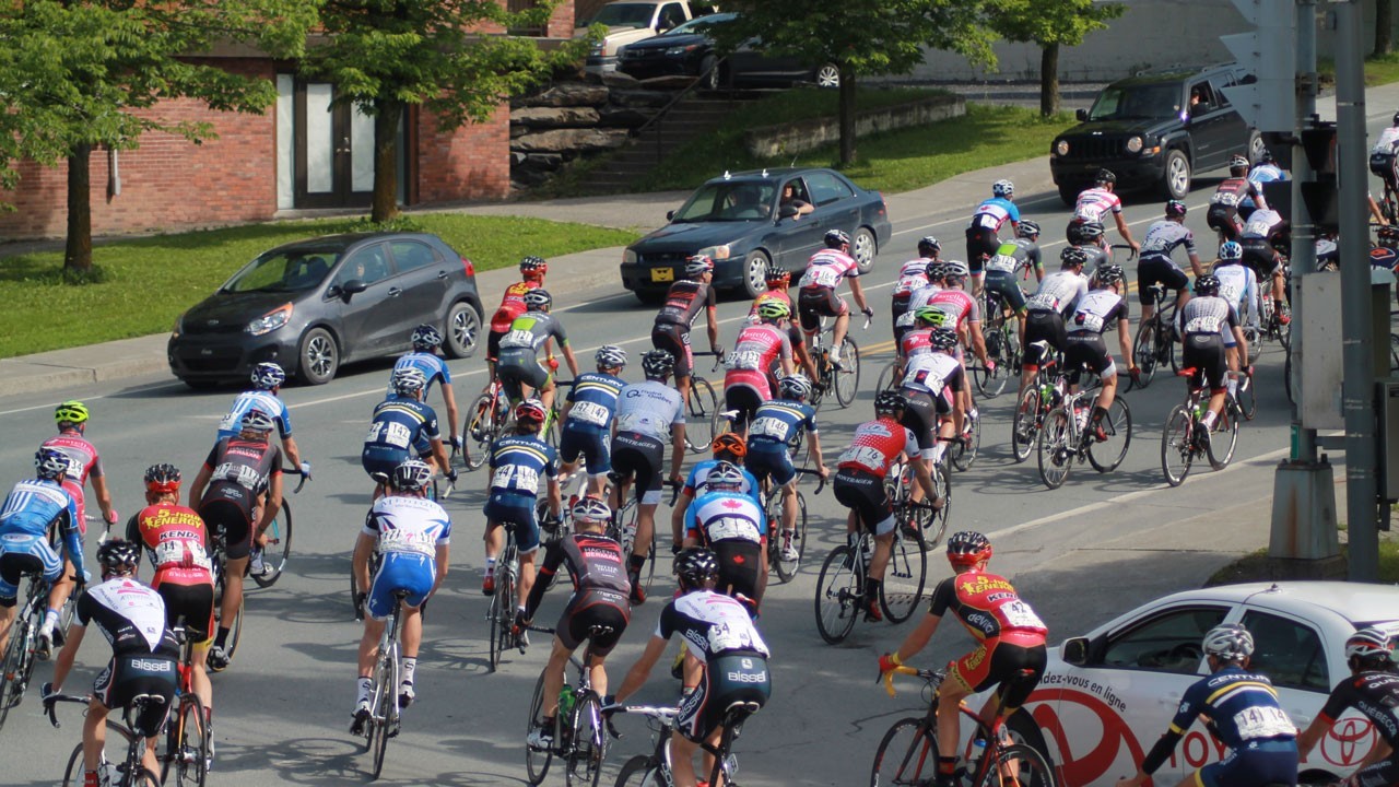 Les cyclistes se dirigent vers le vrai départ à la sortie de la ville.