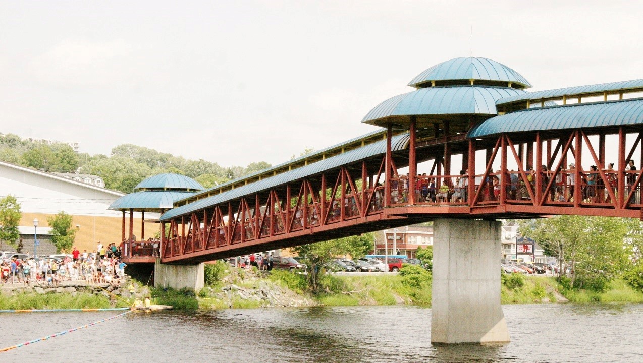 Les gens se sont massés sur la passerelle et sur le long de la rivière pour ne rien manquer de la course