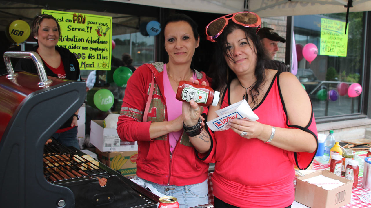 Deux employées, Annie et Nancy, invitent les gens à la vente de hot-dogs.