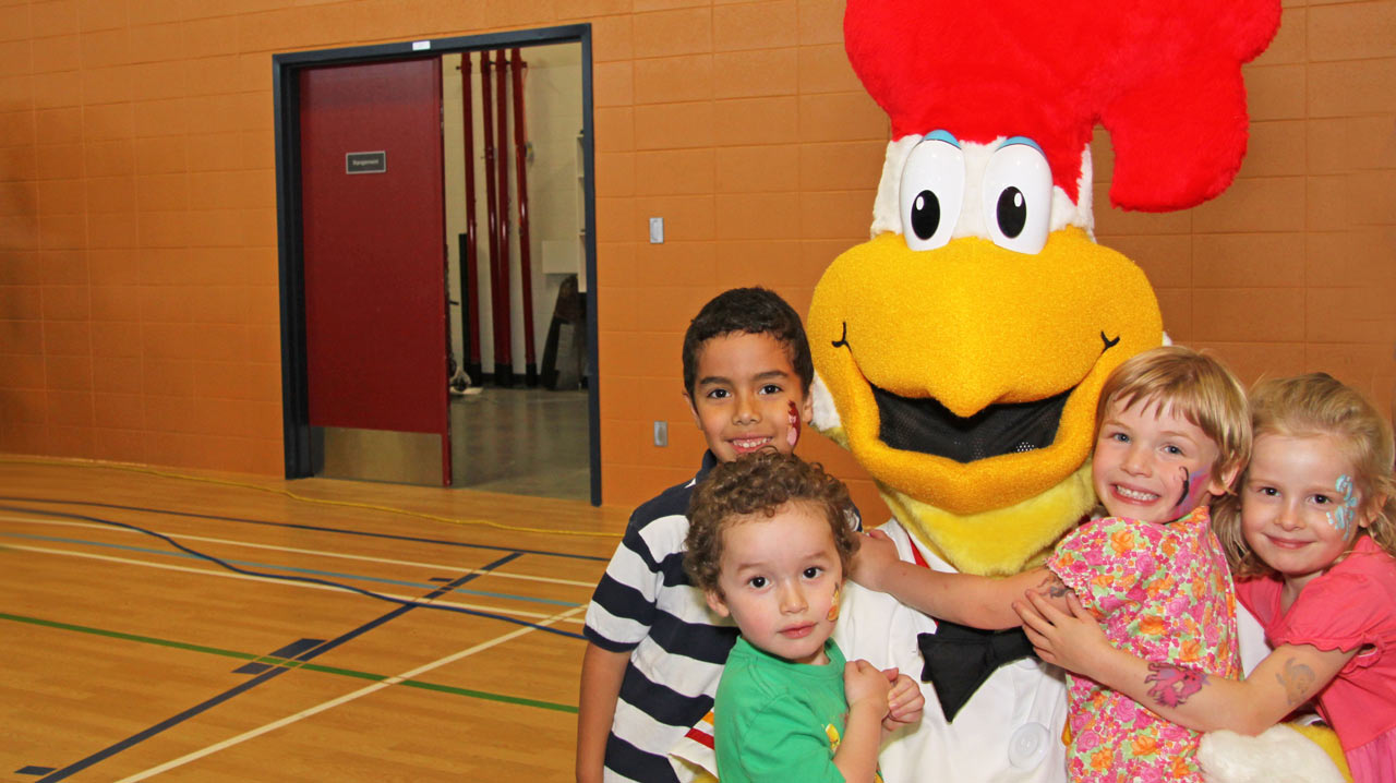  La mascotte Saint-Hubert avec quatre tout-petits, les enfants aiment les mascottes

