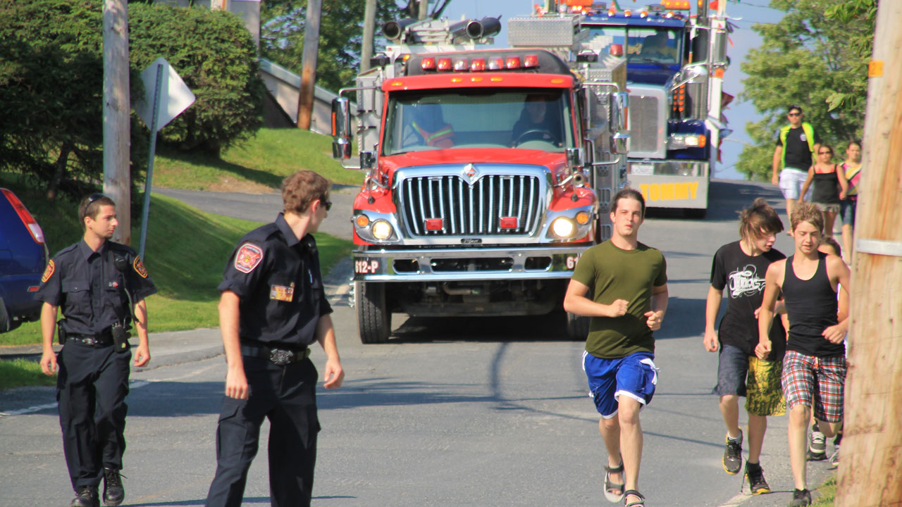 Les jeunes courent pour devancer la parade.