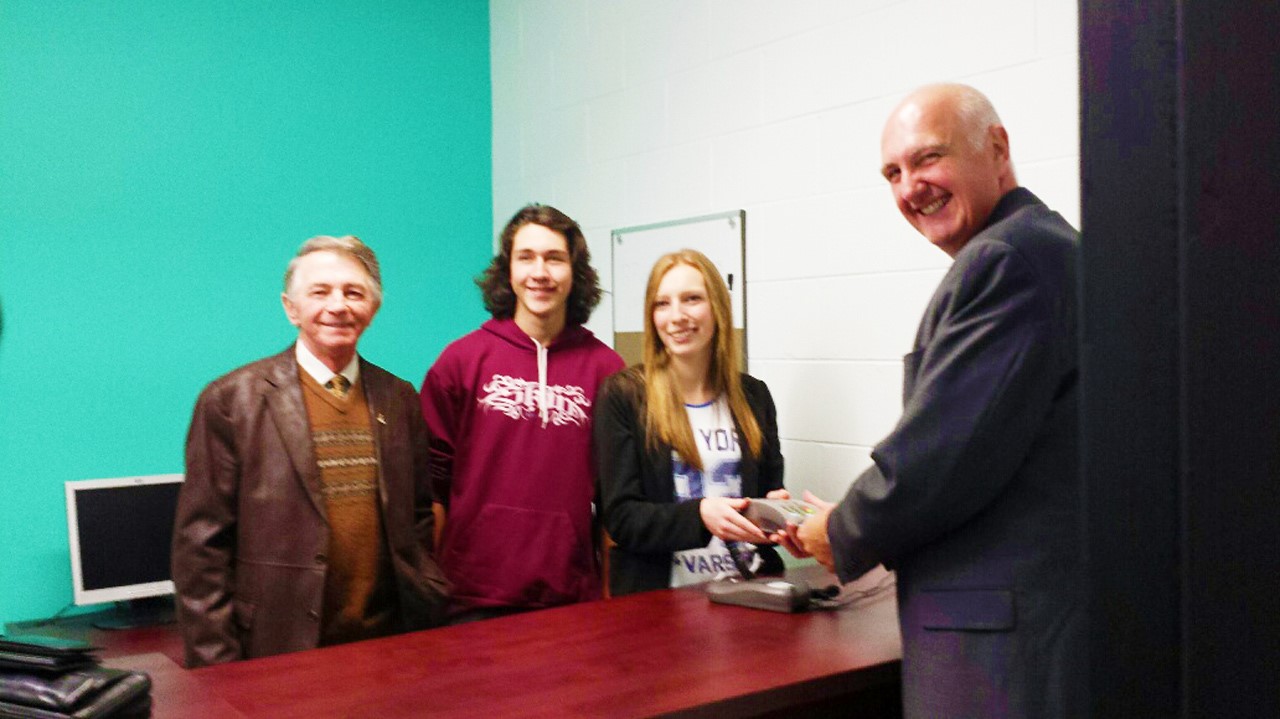 Normand Lessard, directeur général de la CSBE (devant) montre comment s'effectue une transaction au local de la caisse étudiante.
Derrière, de gauche à droite: Charles-Henri Lecours, président de la Commission scolaire Beauce-Etchemin, Steven Carrier, responsable aux ressources humaines et des opérations de la caisse étudiante, et Sabrina Thompson, présidente de la caisse étudiante