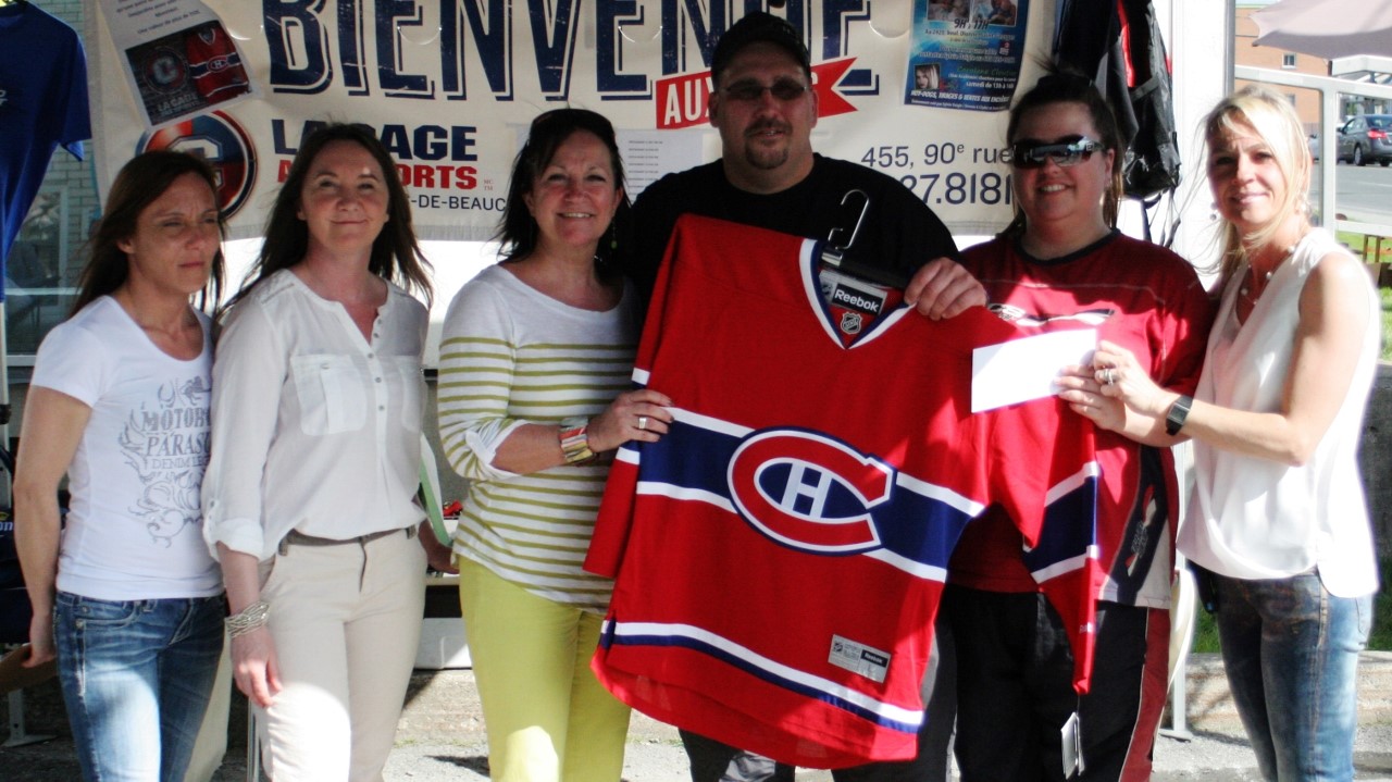 Sylvain Dulac, le gagnant des billets et du chandail des Canadiens de Montréal, pose en compagnie de Gisèle Labonté, de la Cage aux sports de Saint-Georges, et des coorganisatrice de l'événement.