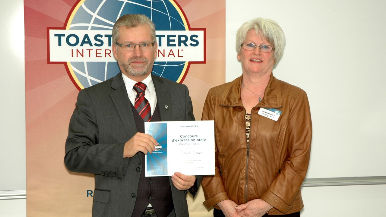 Daniel Garant reçoit des mains de Lucie Dubé, directrice du secteur 91 de la Division I de Toastmasters, son certificat de meilleur évaluateur.
