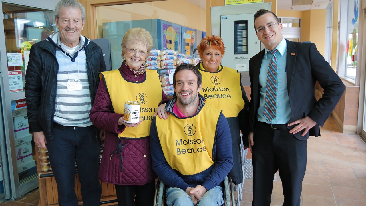L'athlète paralympique Jean-Philippe Maranda en compagnie de bénévoles et du gérant de magasin lors de son passage au IGA Extra à Saint-Georges.