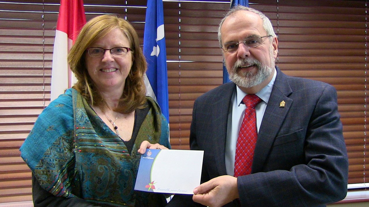 La gagnante du concours « Noël dans ma cité », Louise Champagne, a reçu son prix des mains du maire de Saint-Georges, Claude Morin.