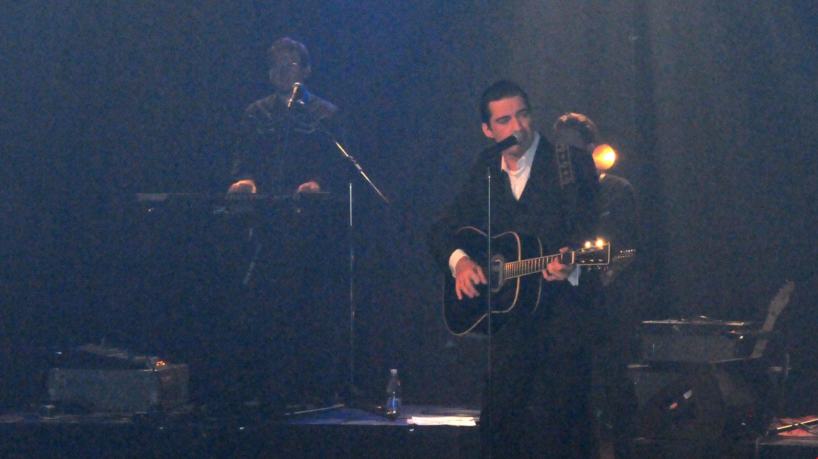 Une salle comble salue l'homme en noir