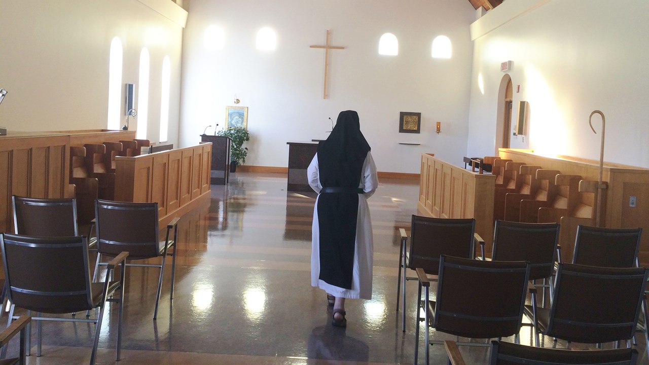 Mère Supérieure se dirige vers l'autel de la chapelle.