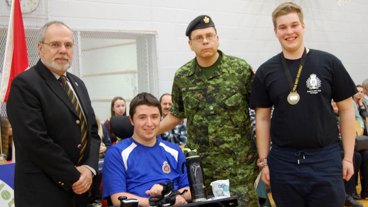 Le cadet Bernard Vallée reçoit des mains de Samuel Bruneau la médaille qui porte son nom. Ils sont accompagnés de M. Claude Morin et du major Jean-François Maheux.