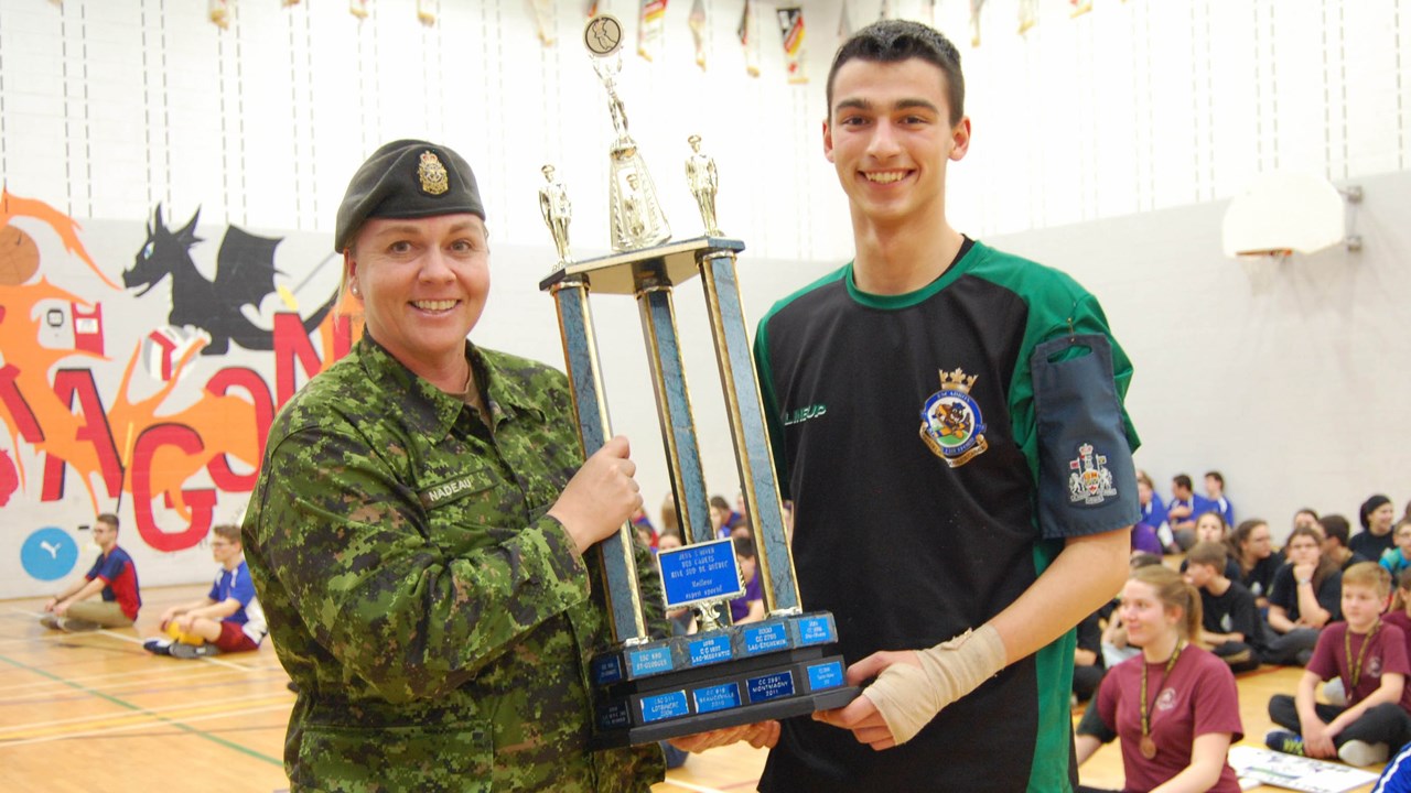 Le cadet commandant de l’escadron 775 de Thetford Mines reçoit le trophée de l’esprit sportif des mains du major Sonia Nadeau.