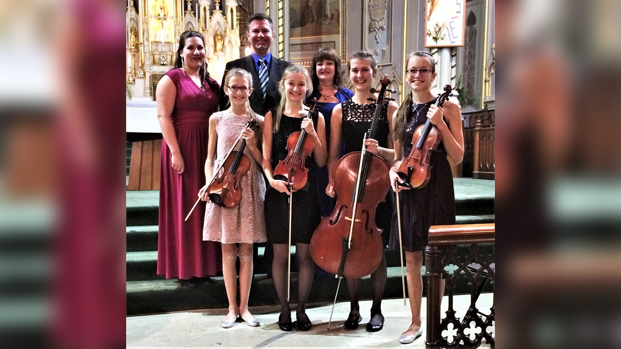 En arrière-plan : les sopranos Evelyne Larochelle et Rachelle Thibodeau, entourant le pianiste Dominique Gagnon. Au premier plan : les quatre soeurs Berthiaume, violonistes et violoncellistes.