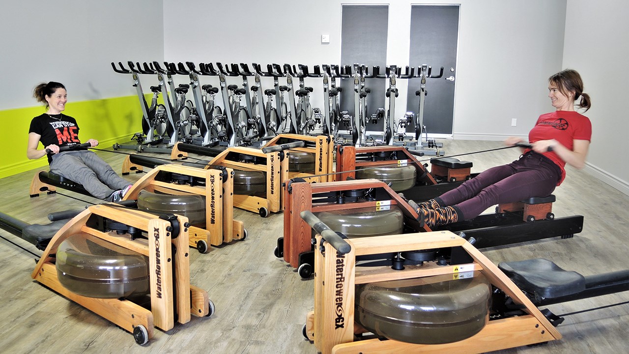 Spinning de Beauce offrira dans son nouvel environnement, situé dans les locaux du Studio Santé Gym 24 h de Saint-Georges, des cours de spinning, de cardio-rameur, de pilates, de stretching et d'entraînement Essentrics. Sur la photo, Sophie Veilleux (à gauche), gérante et entraîneure chez Spinning de Beauce, et Hélène Lessard (à droite), entraîneure chez Spinning de Beauce, s'adonnent au cardio-rameur dans leurs nouveaux locaux.