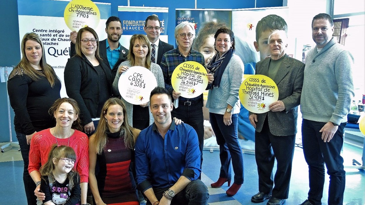 Les porte-paroles d'Opération Enfant Soleil, Mélanie Gagné et Étienne Drapeau, accompagnés de l'Enfant Soleil de Chaudière-Appalaches, Megan Prévost, ainsi que des représentants des hôpitaux et organismes récipiendaires des octrois.
