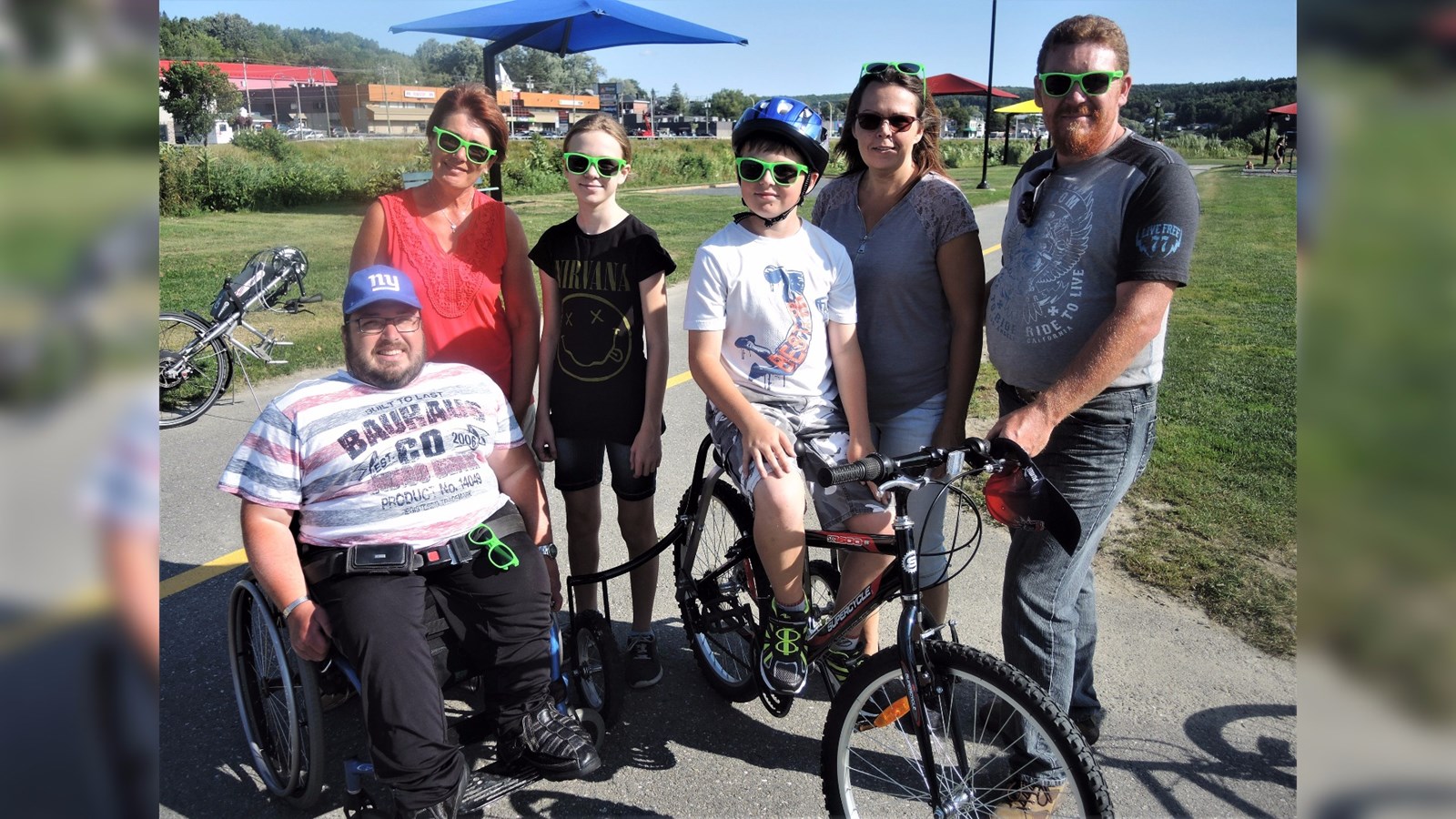 Les deux athlètes beaucerons Sylvain Tardif (à gauche), originaire de Saint-Georges, et Gabriel Gosselin (au centre sur le vélo), originaire de Saint-Victor, accompagnés de leurs familles. Tous deux pratiquent le hockey sur luge à l'aréna de Beauceville et font partie de l'équipe de hockey sur luge de la Chaudière-Appalaches.