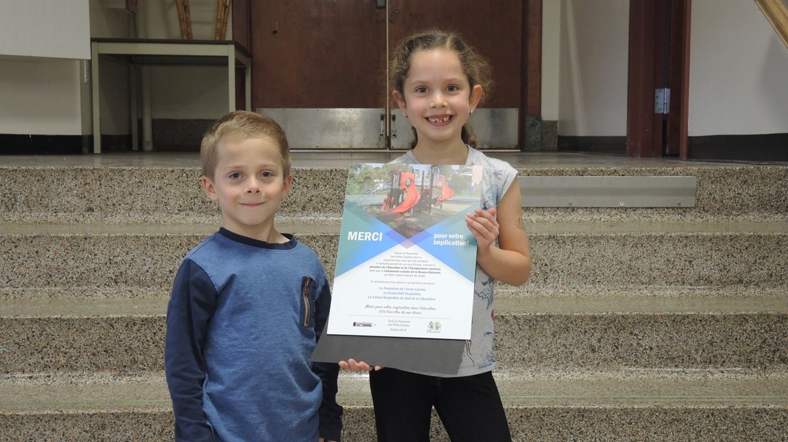 Deux élèves de l'école avec la plaque.