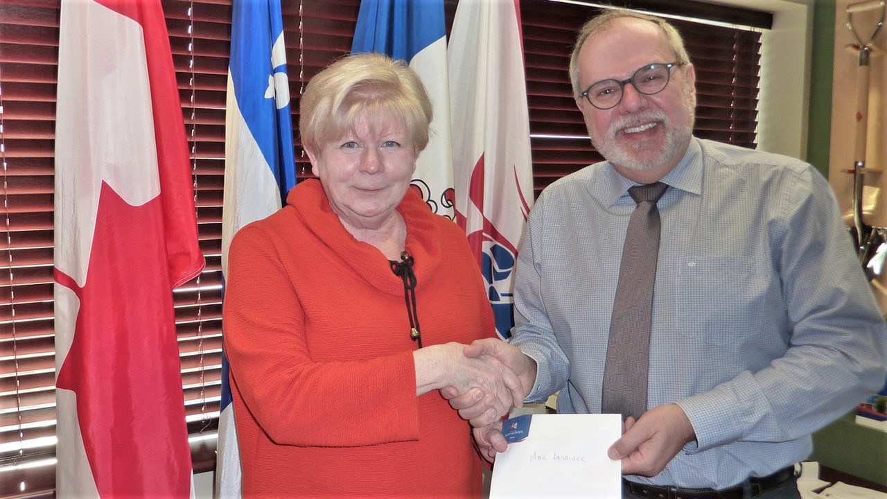 Le maire de la Ville de Saint-Georges, Claude Morin, à droite, remet la bourse de 400 $ à Colombe Larrivée, de Saint-Georges, à gauche, gagnante de la 5e édition du concours en arts visuels « Noël dans ma cité ».