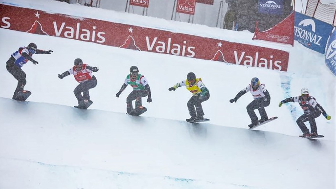 L'athlète de Sainte-Marie en snowboard cross, Éliot Grondin, porte un dossard noir (à droite) lors de sa descente dans une vague à six en demi-finale (petite finale) pour la Coupe du monde de Veysonnaz, en Suisse, samedi le 17 mars 2018.