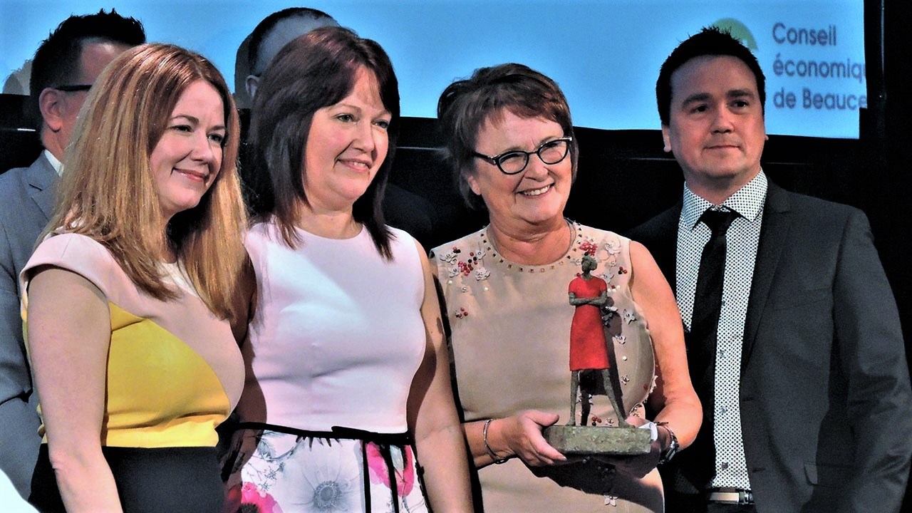Claire Boutin, récipiendaire du Prix Jean-Denis Poulin, entourée de ses enfants, avec la sculpture réalisée par l'artiste beauceron Paul Duval intitulée « L’audacieuse ».