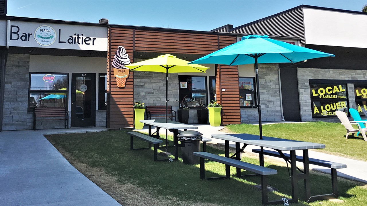 Le bar laitier Plaisir sans faim, situé au 647, 14e Avenue, La Guadeloupe, à droite du Dollarama, met à la disposition de ses clients huit tables de pique-nique et une vingtaine de chaises colorées à l'extérieur.