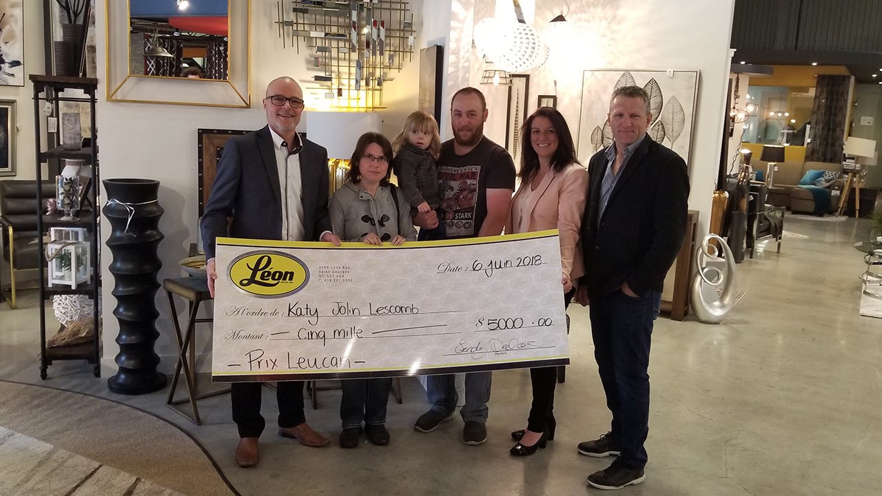 Kathy Jolin Lescomb, gagnante du chèque-cadeau de 5000 $ chez Meubles Léon Saint-Georges, entourée de son conjoint, de sa fille, de Gilbert Trudeau et d'un responsable chez Meubles Léon.