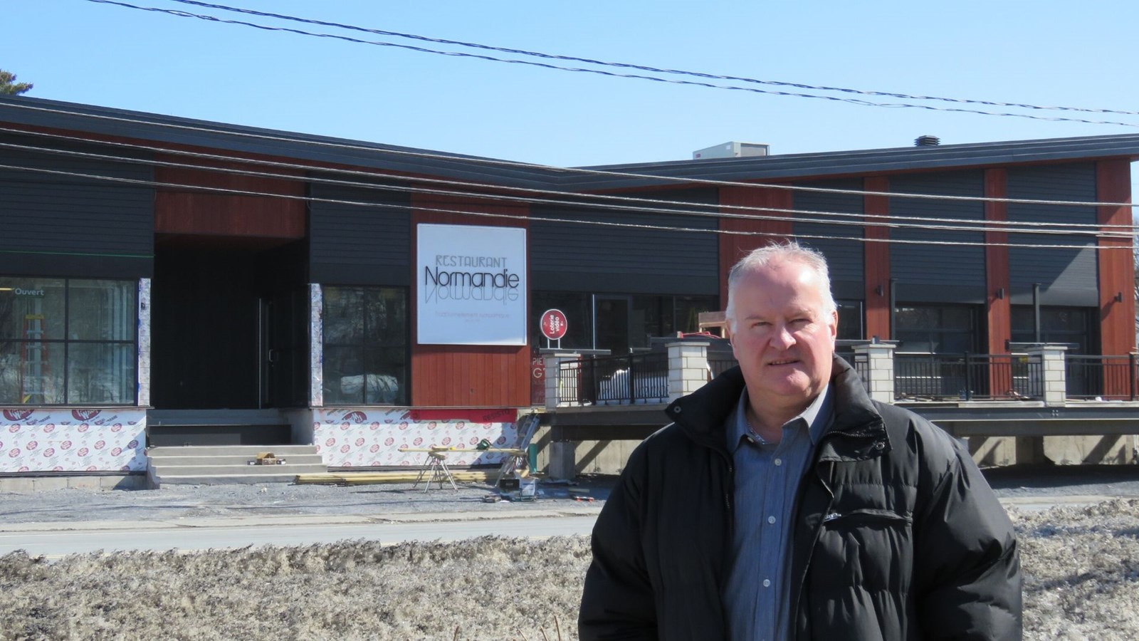 Le maire, François Veilleux, posant devant le tout nouveau restaurant Normandie/Bar l’Entracte et le restaurant Subway.