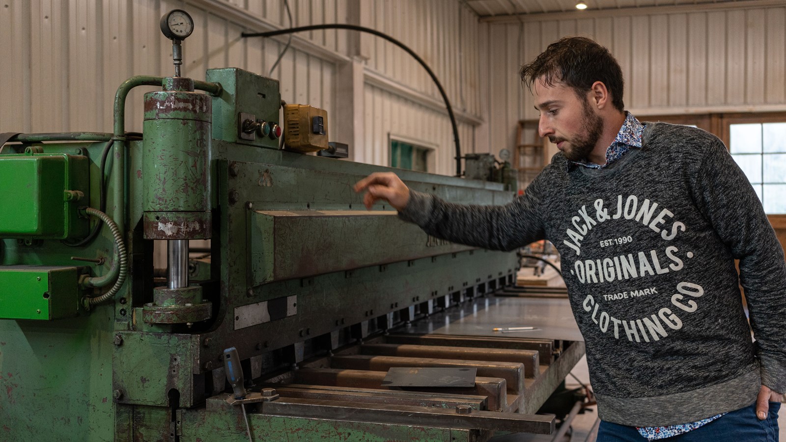 Samuel Rodrigue qui montre le fonctionnement de la découpeuse