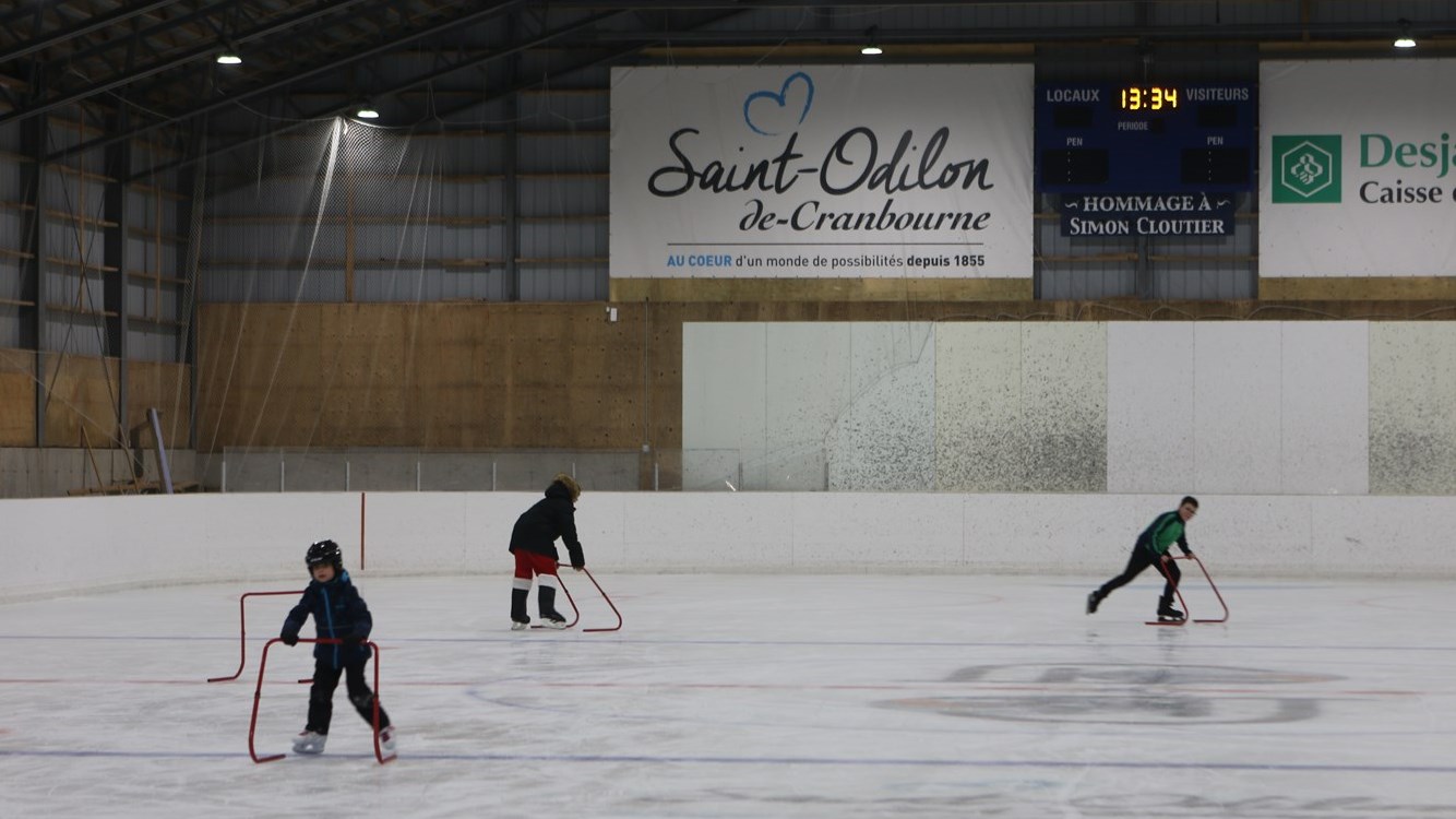 Trois jeunes qui patinent lors du marché de Noël de Saint-Odilon.