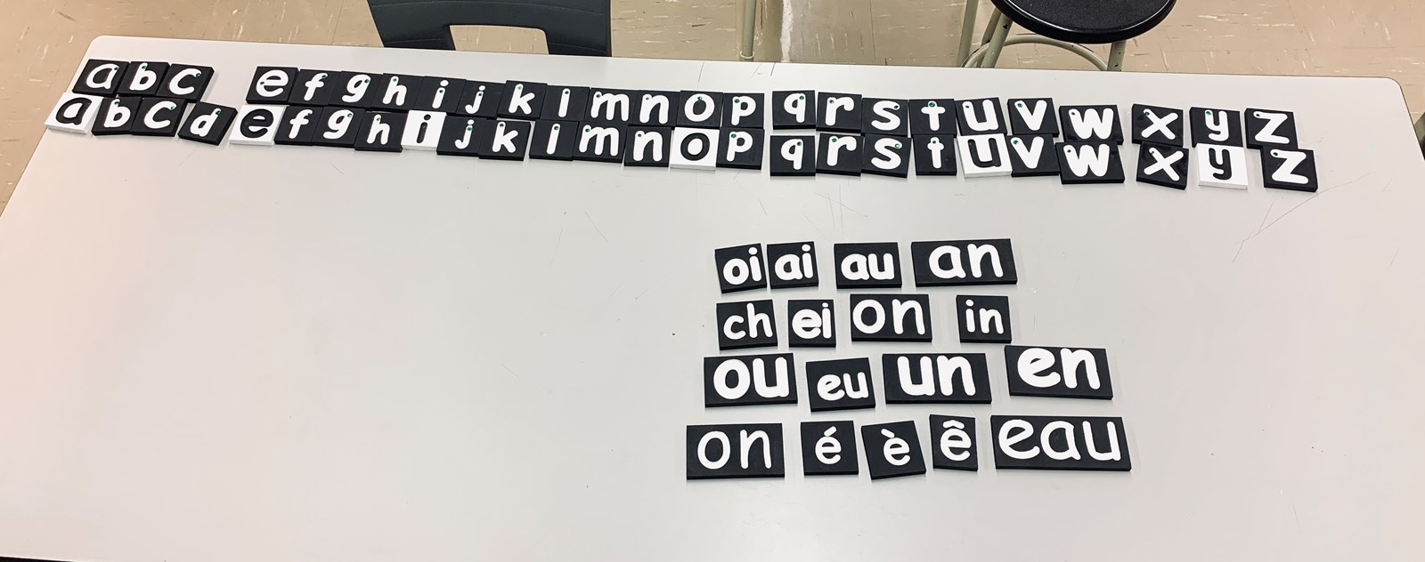 Des lettres et des sons gravés et peinturés permettant aux élèves de la classe COM de manipuler et de toucher la lettre en passant le doigt dans la gravure.
