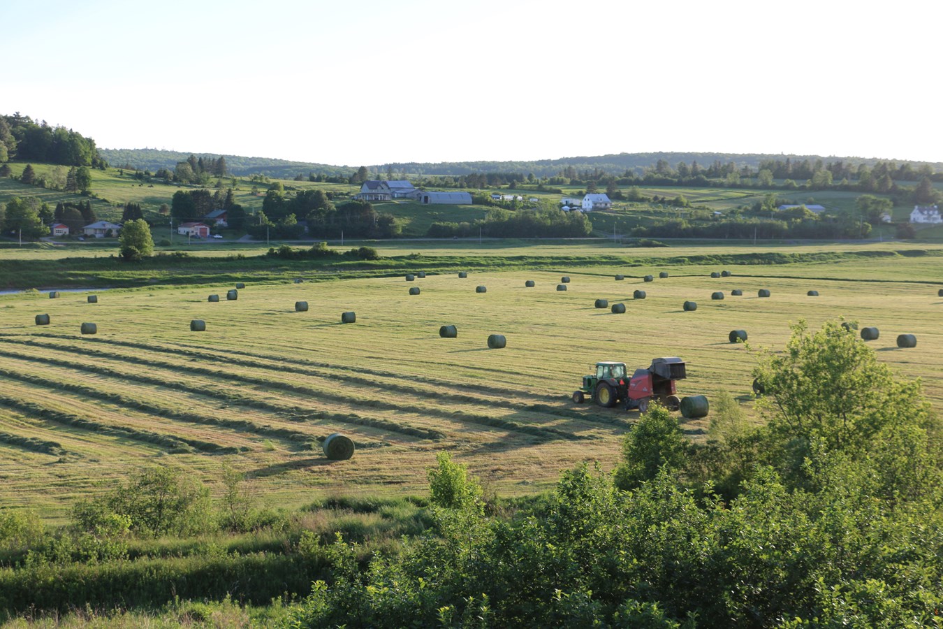 Agriculteur de Beauceville pressant des balles rondes un mercredi soir.