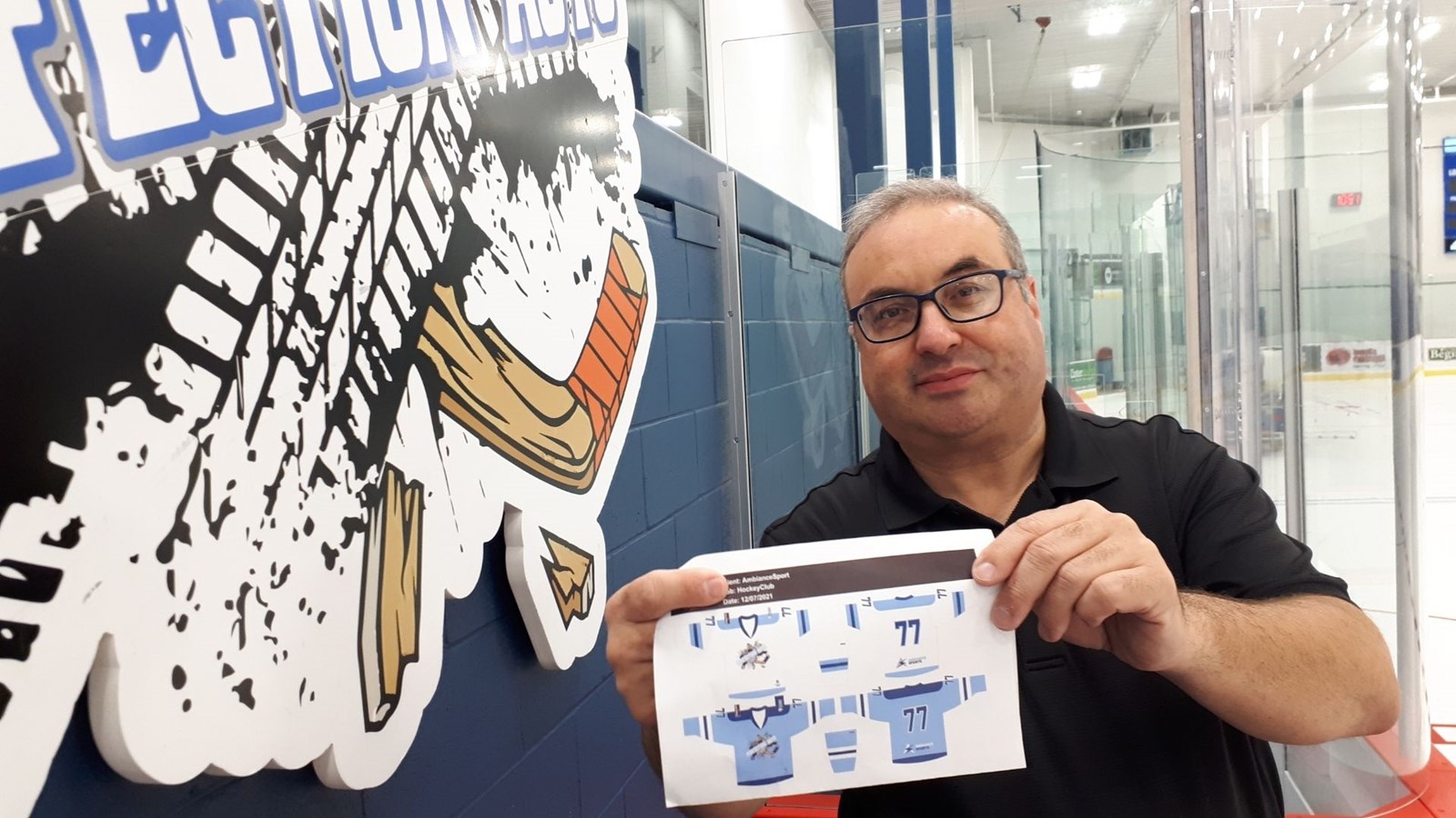 L'entraîneur-chef, Stéphane Poulin, montre de quoi auront l'air les nouveaux chandails.
