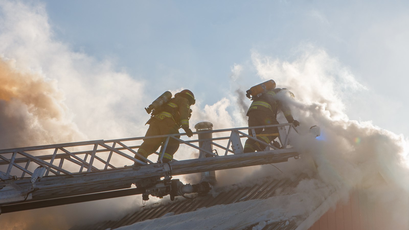 Des pompiers grimpent au toit de la résidence par le camion échelle du service incendie de Lac-Etchemin
