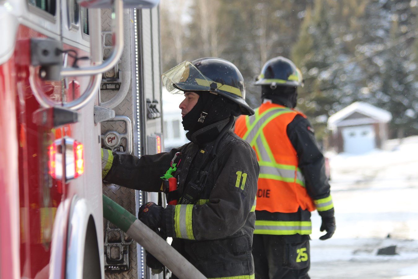 Un pompier de Saint-Georges opérant l'autopompe sur un incendie de garage résidentiel