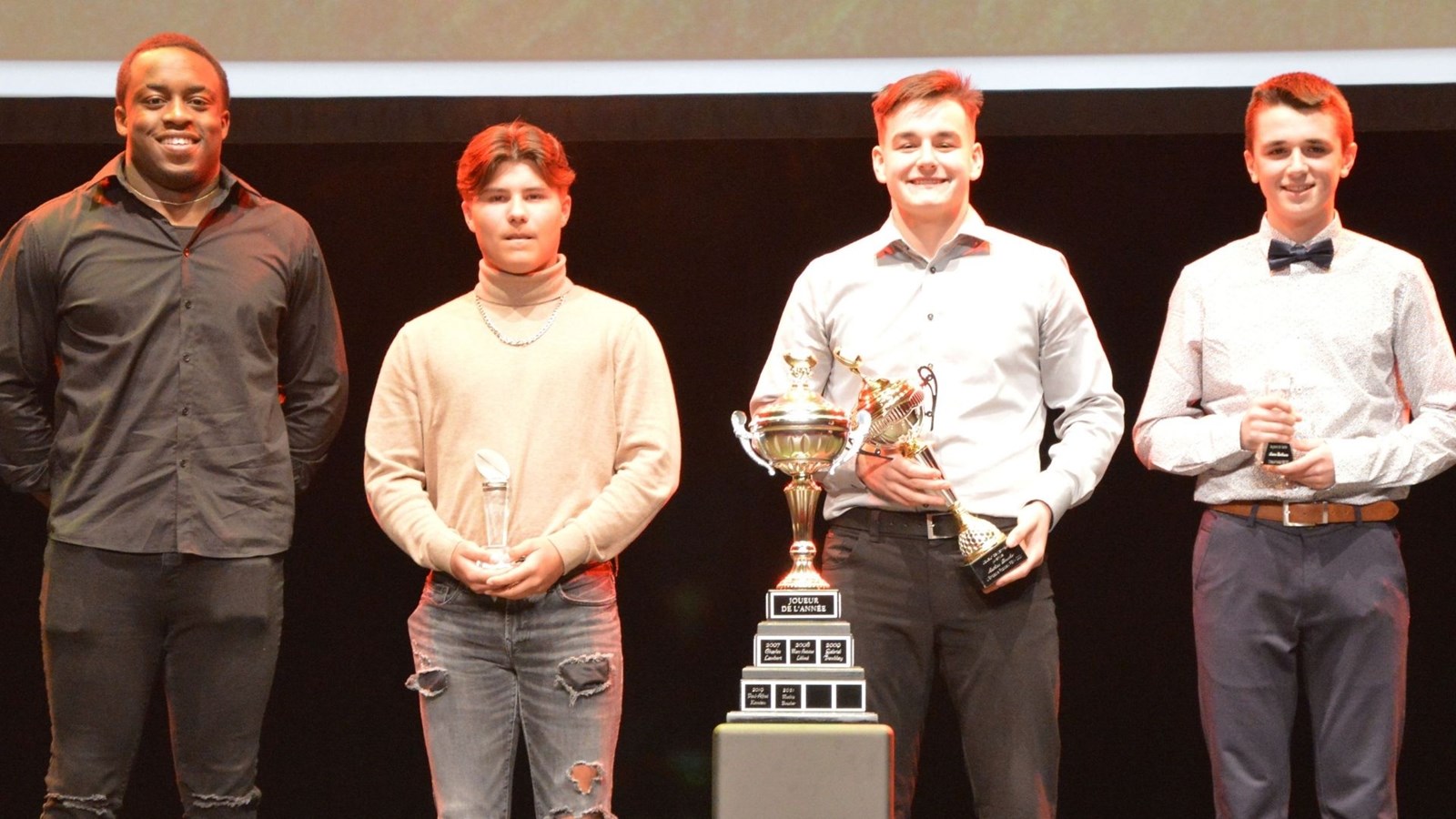 Paul-Alfred Kamdem accompagné des trois joueurs de l’année : Demrick Gagné (cadet), Mathias Boucher (juvénile) et Antoine Berthiaume (atome).