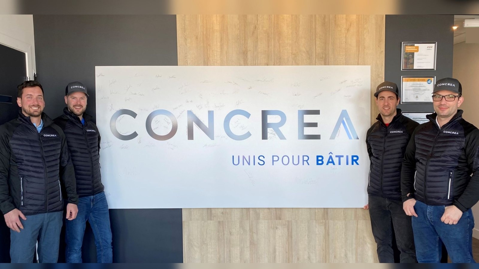 Les quatre associés de CONCREA devant l’affiche signée par les employés en souvenir du lancement officiel du nouveau nom: Maxime Veilleux, vice-président et directeur général, Derek Tardif, directeur financier, Darren Bolduc, président et Patrice Beaulieu, directeur de développement