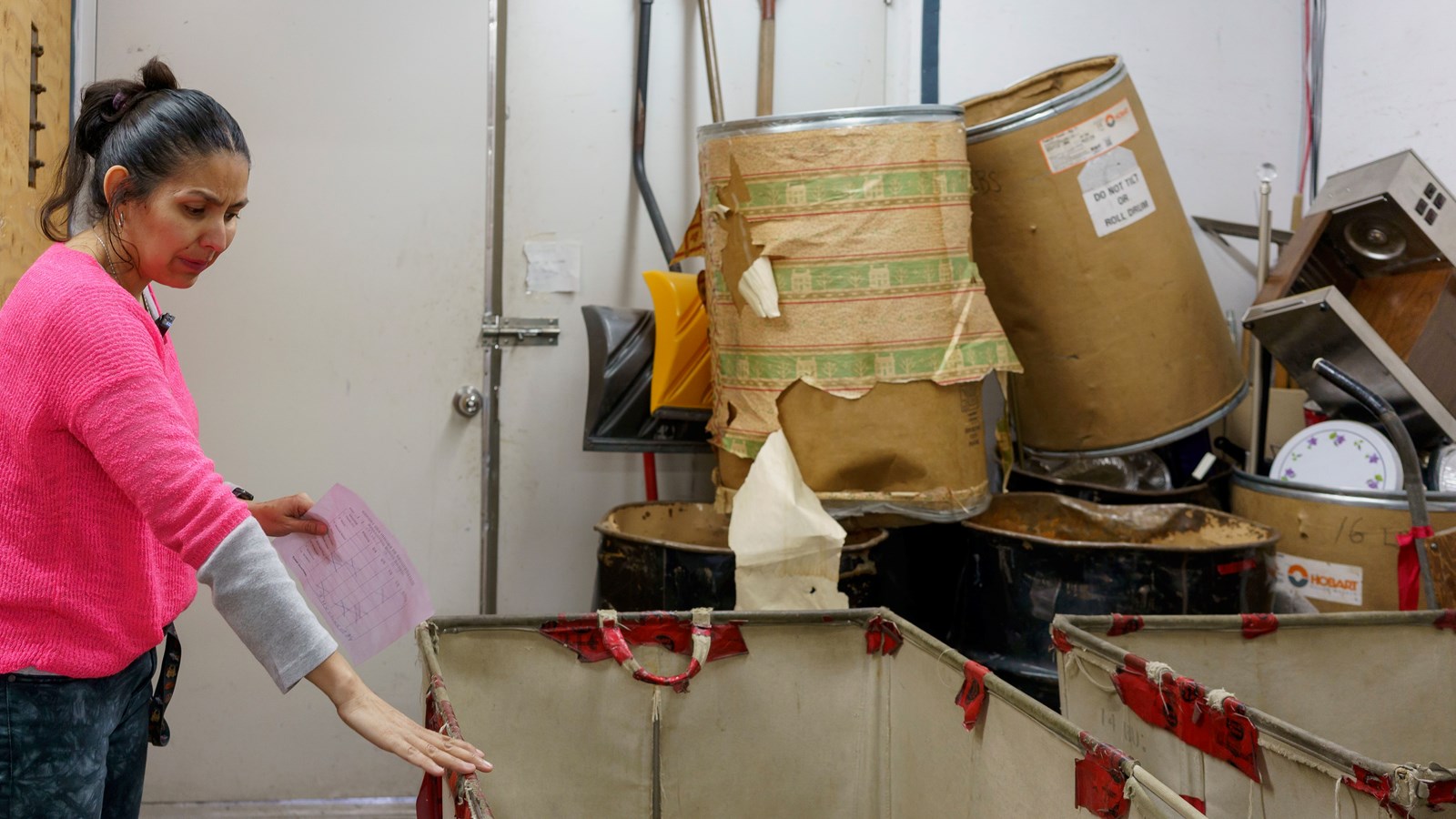 Les sacs de vêtements sont transportés d’un bout à l’autre du bâtiment dans de grands bacs en plastique sur roulettes.