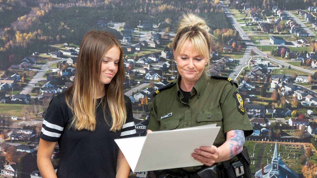 L'agente Marie-Joëlle Girard, coordonnatrice en police communautaire au poste de la MRC Nouvelle-Beauce, remet un certificat de collaboration au nom de la Sûreté du Québec