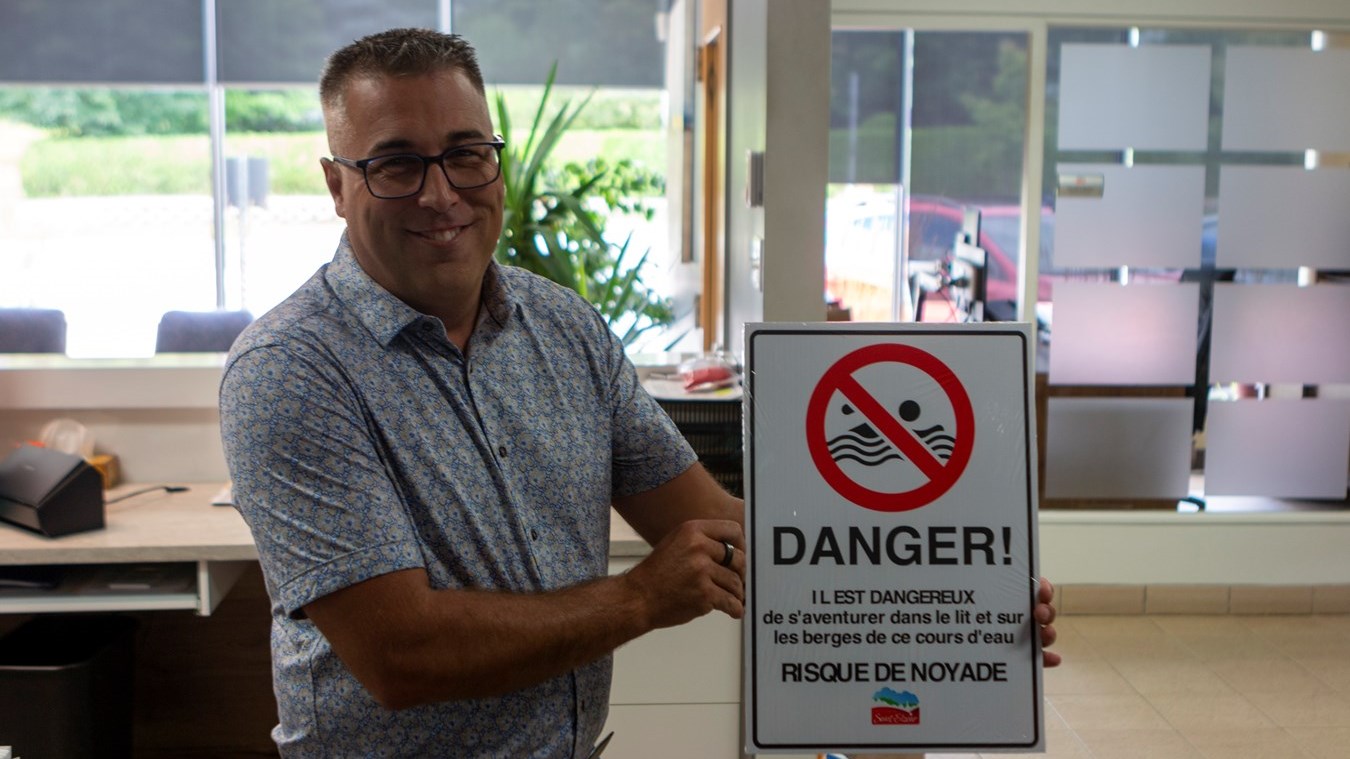 Carl Marcoux, présentent les panneaux qui seront installés au abord de la rivière Savoie