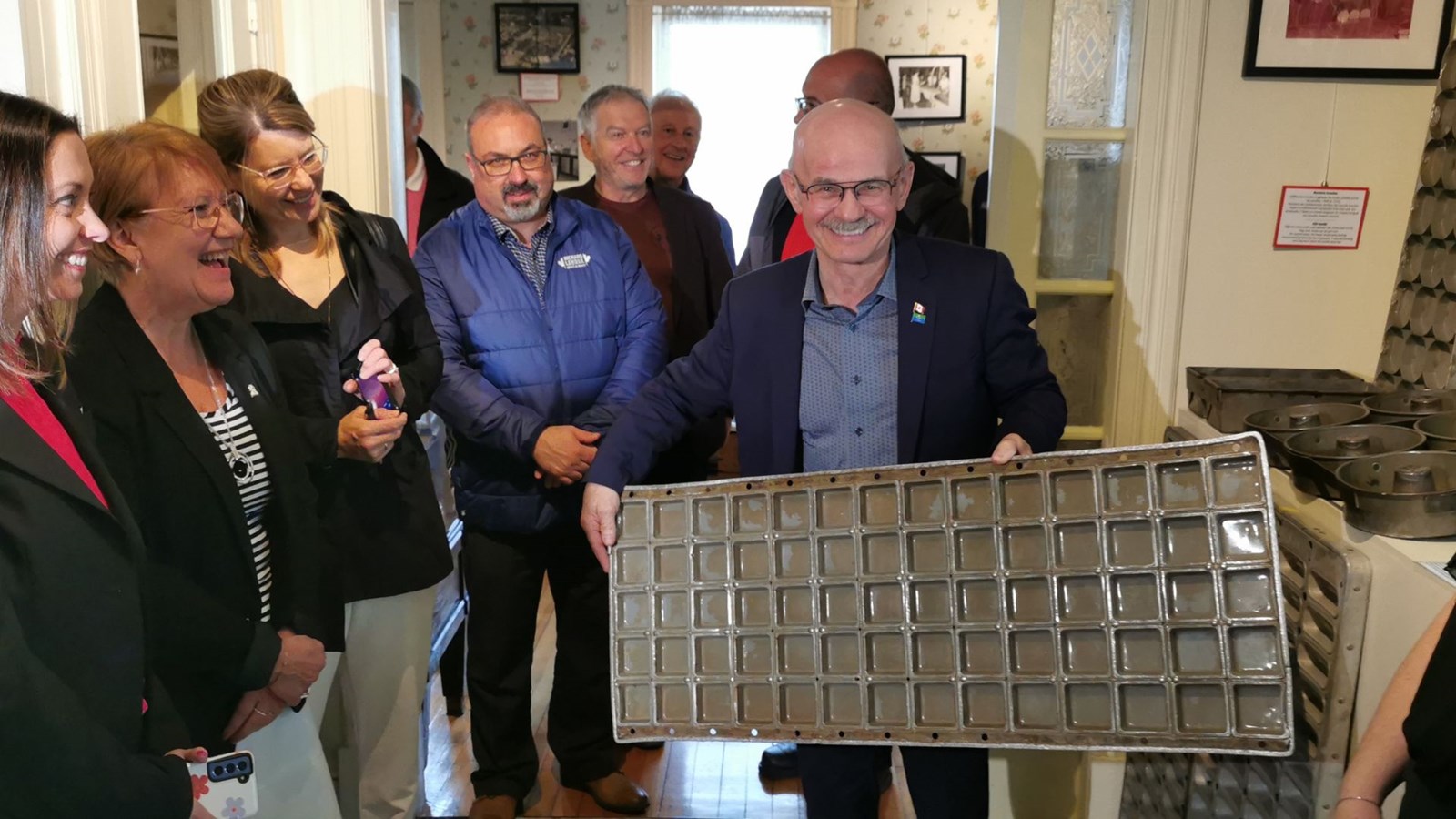 Le député Richard Lehoux tenant un ancien moule pour la fabrication des Ah! Caramel.