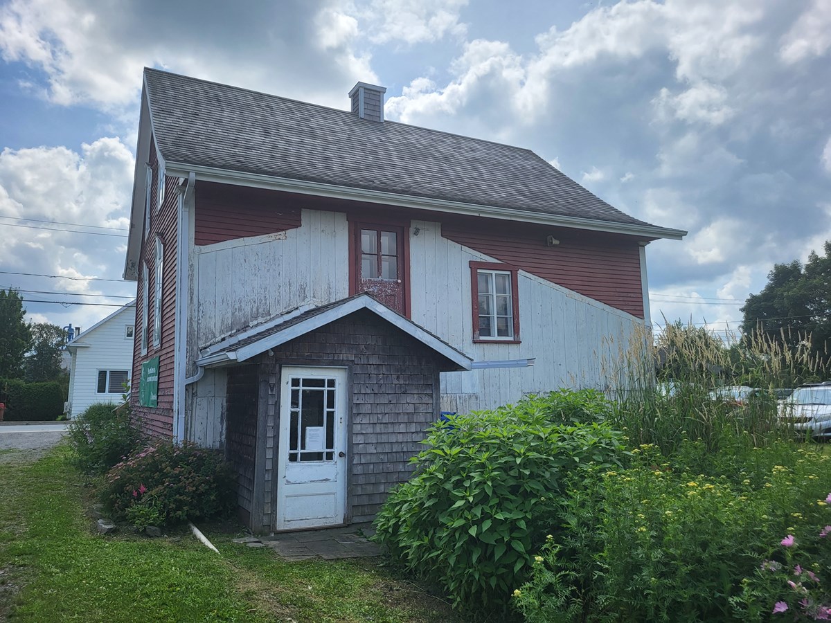 Vue arrière de la maison rouge, donnant accès à l'exposition du sous-sol.
