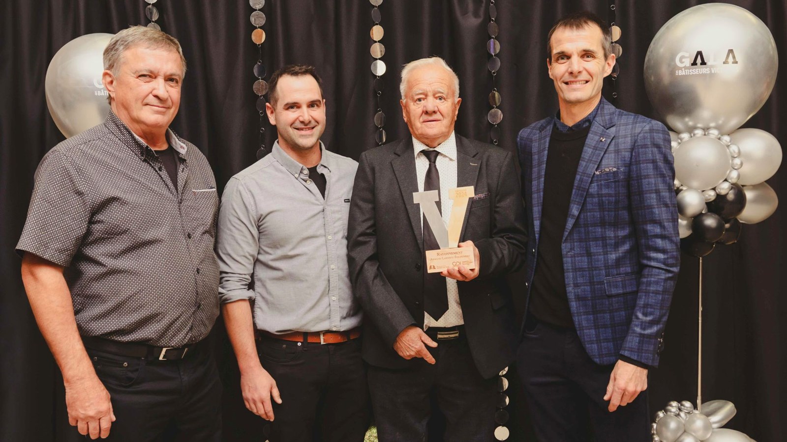 Le Bâtisseur Rayonnement a été décerné au commerce Armand Lapointe Équipement. On voit le fondateur, Armand Lapointe, tenant le trophée, en compagnie des propriétaires, Marco Lapointe propriétaire et Raphaël Thivierge. Prix remis par André Bizier, président de CDI Saint-Victor.