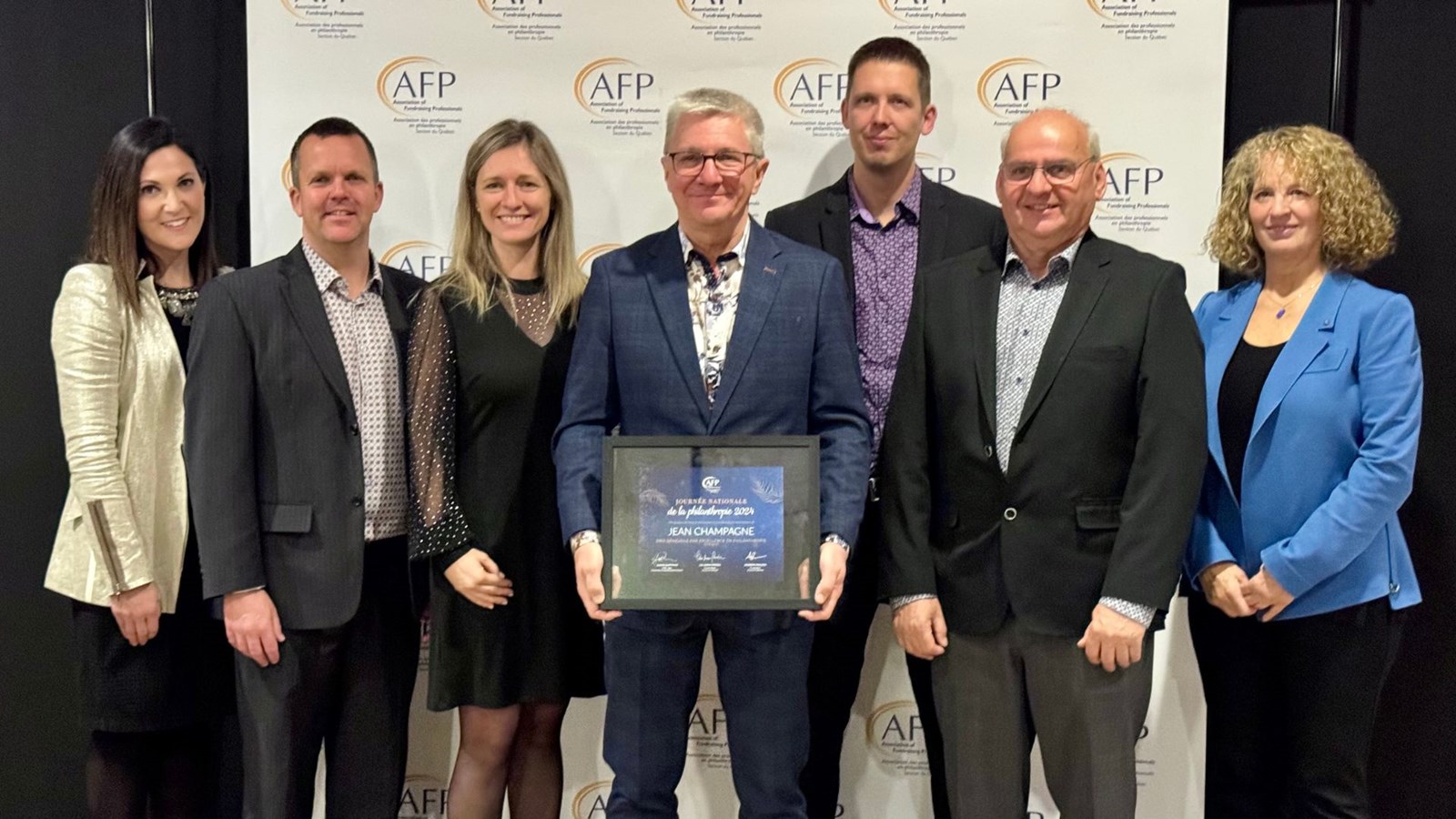 Au centre, Jean Champagne, qui a reçu le  Prix Bénévole par excellence en philanthropie entouré d'Alexis Gaiptman, présidente de l’AFP division Québec, François Langevin, représentant de la Fondation des Sports et Loisirs de Beauceville, Marie Champagne, présidente de la Corporation du quartier de la débâcle de Beauceville, Éric Poulin, directeur du Club Parentaide Beauce-Centre, Benoit Giraudeau, représentant l'organisme Cultiver pour partager, ainsi que Lili-Anna Pereša, présidente-directrice générale sortante de la Fondation McConnell.