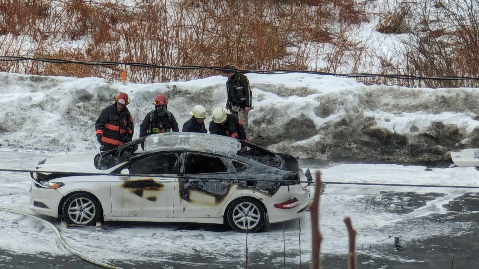 Une voiture détruite par le feu dans le stationnement du Cabaret Bar 55