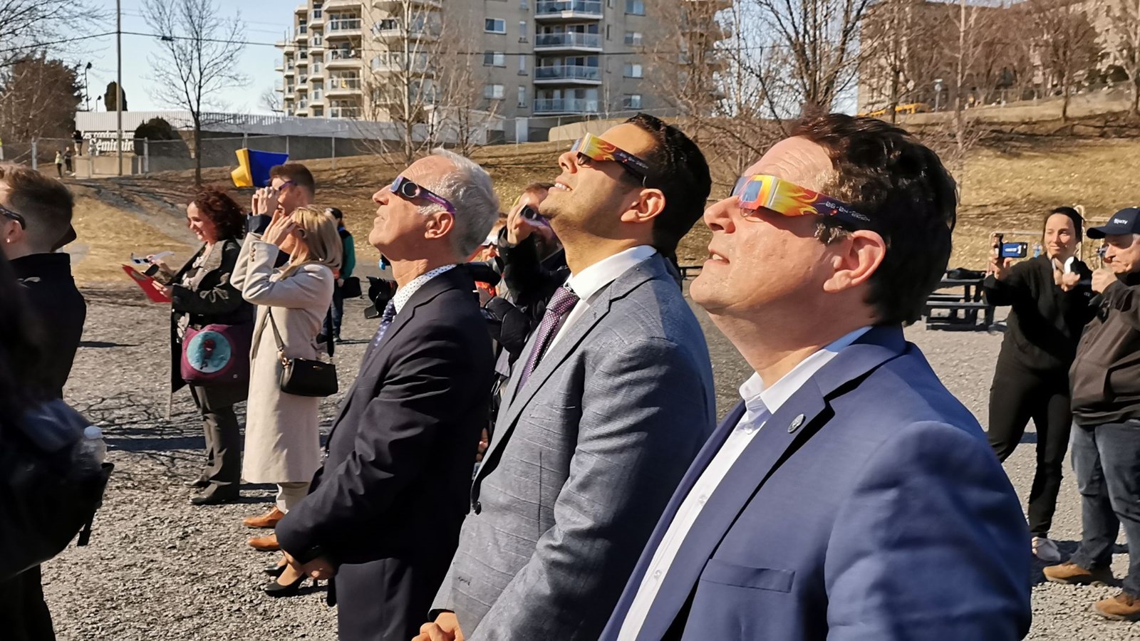 À l'avant-plan, le ministre de l'Éducation, Bernard Drainville, en observation de l'éclipse en compagnie du député de Beauce-Sud, Samuel Poulin et du directeur général du CSSBE, Fabien Giguère.
