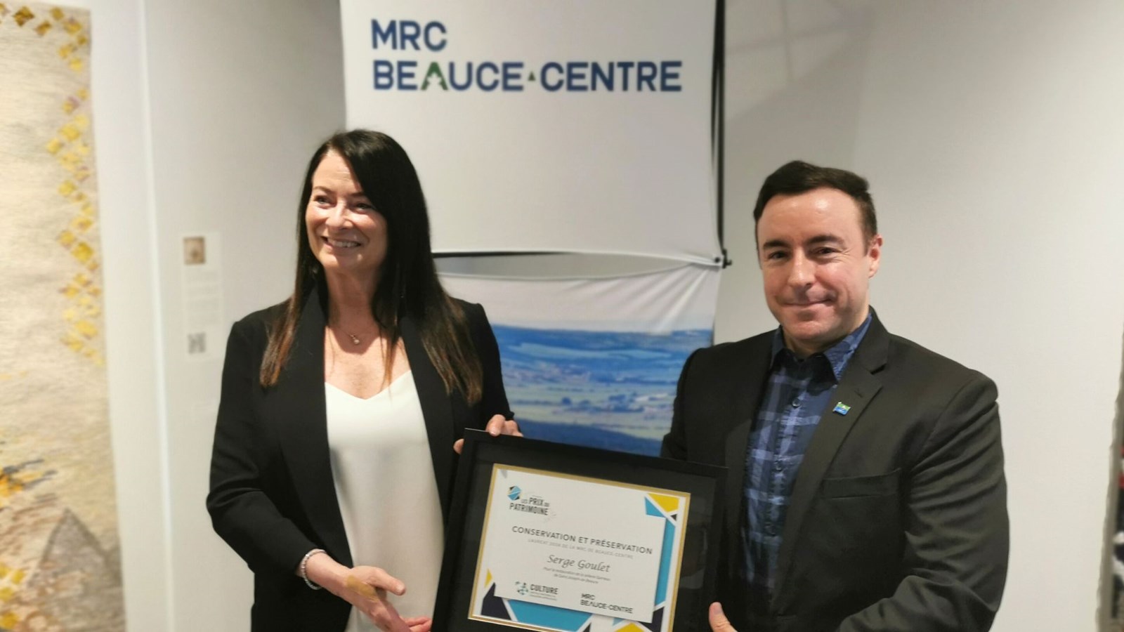 Conservation et préservation pour Beauce-Centre: prix décerné à Serge Goulet, représenté ici par sa conjointe. C'est le préfet Jonathan V. Bolduc qui a remis le certificat.