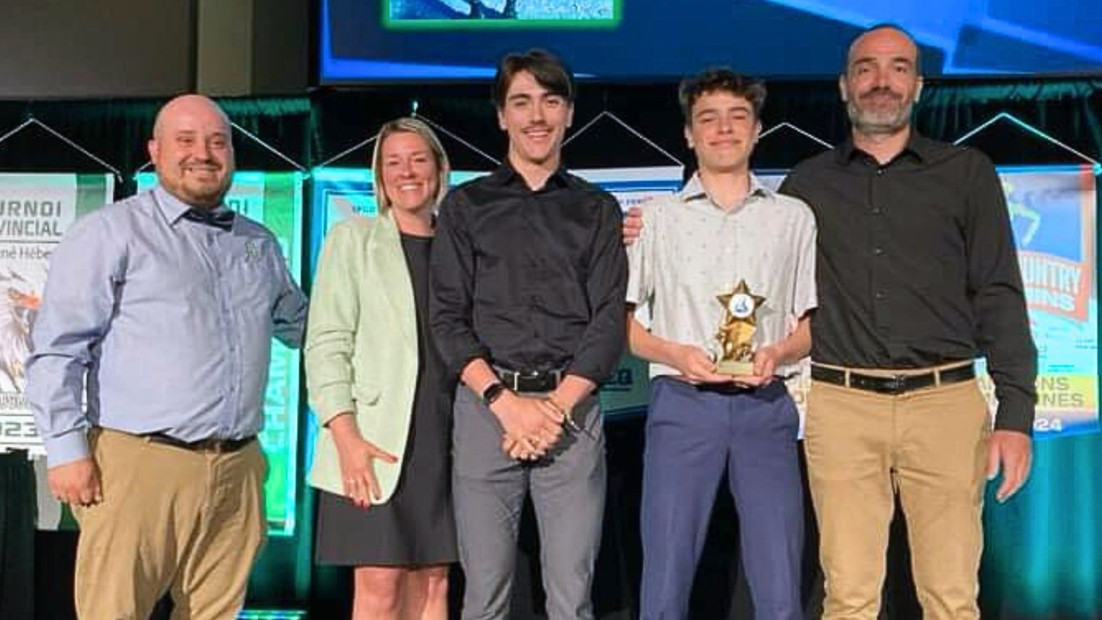 On aperçoit Eliott Drouin, tenant le «Trophée Marylène-Laplante», remis à l'athlète par excellence de l'année, entouré de Simon Grenier, responsable des sports, Anne-Marie Grenier directrice de la Polyvalente Benoit-Vachon, Jacob Lebel, gagnant du même titre l'an dernier, et Patrice Drouin, enseignant en éducation physique.