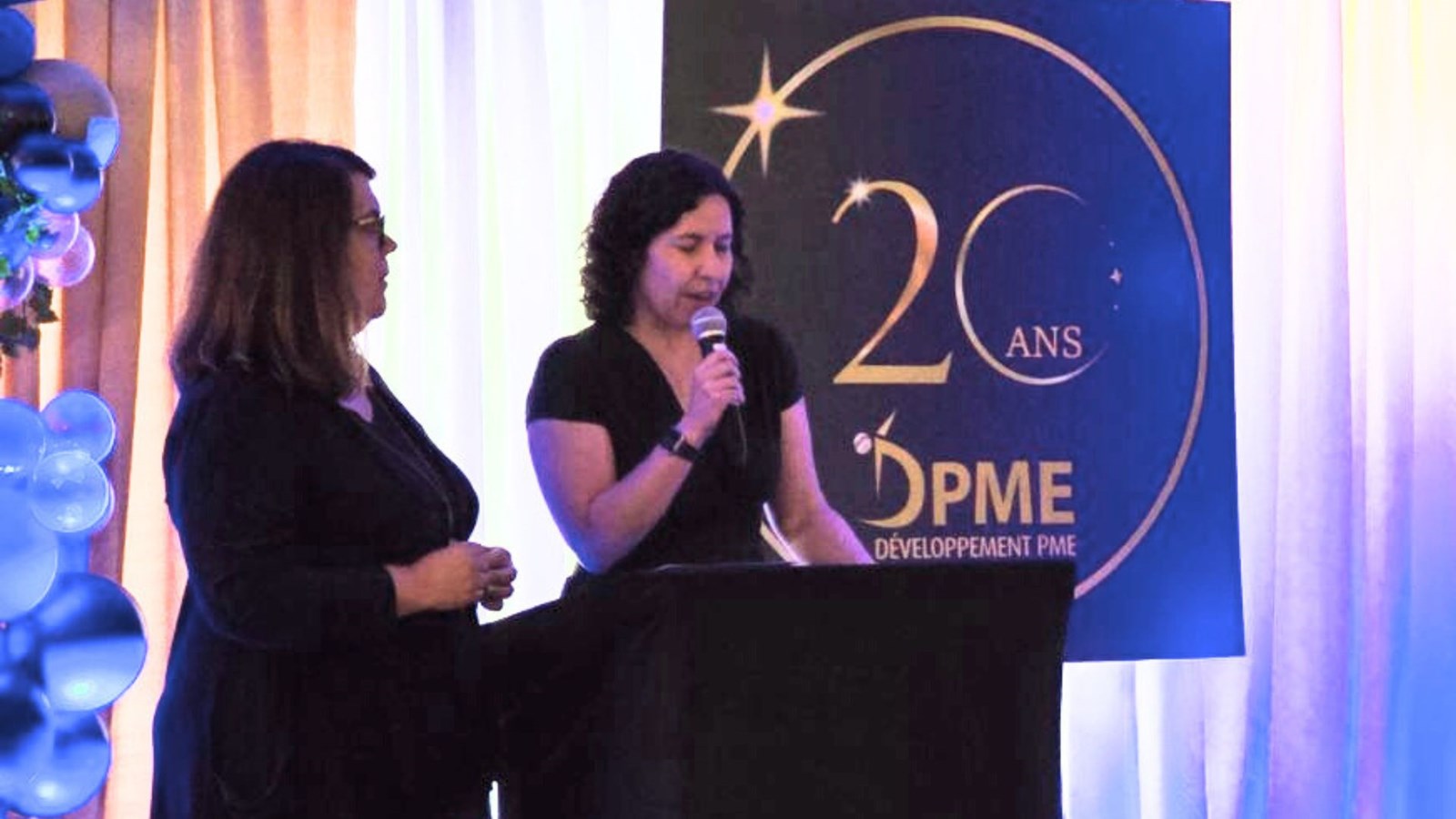 La présidente du conseil d’administration de DPME, Dominique Nadeau, s'adressant aux participants de l'assemblée, en compagnie de la directrice générale de l'organisme, Marie-Pierre Poulin.