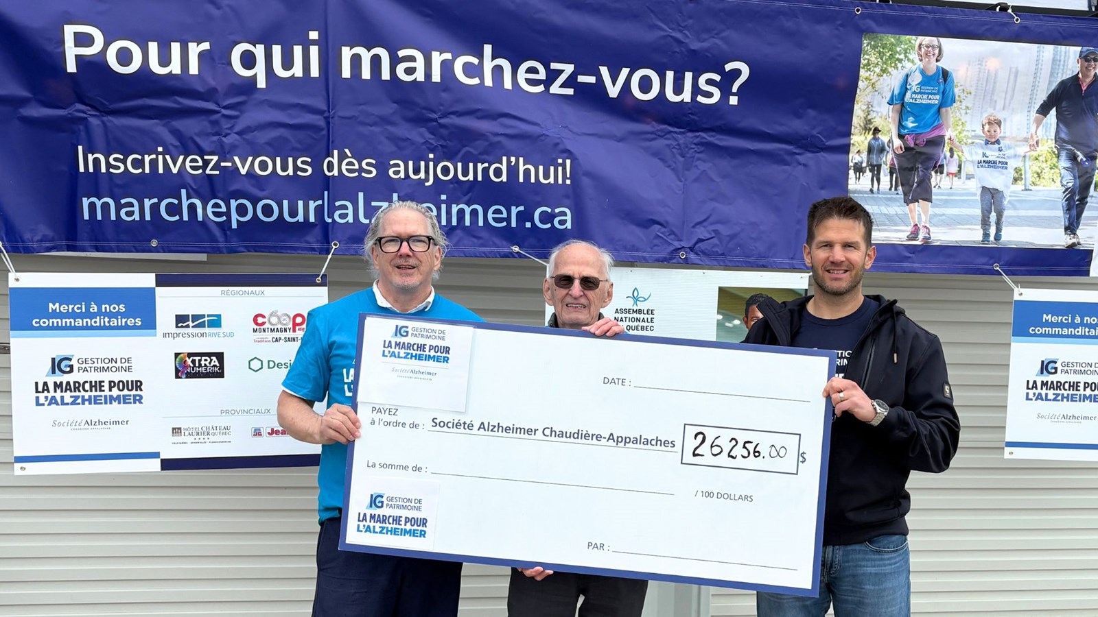 Le directeur adjoint de la Société Alzheimer Chaudière-Appalaches, Yvan Saint-Hilaire, le président du comité organisateur de la marche, Bernard Poulin et la président d’honneur de l'événement, Hugo Lehoux, montrant la somme totale recueillie.