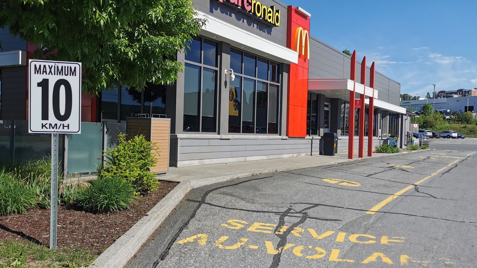 L'un des deux panneaux installés après l'accident, montrant que la vitesse de circulation est limitée à 10 km dans l’entrée du stationnement menant aux voies du service à l’auto et dans le secteur de réception des commandes.
