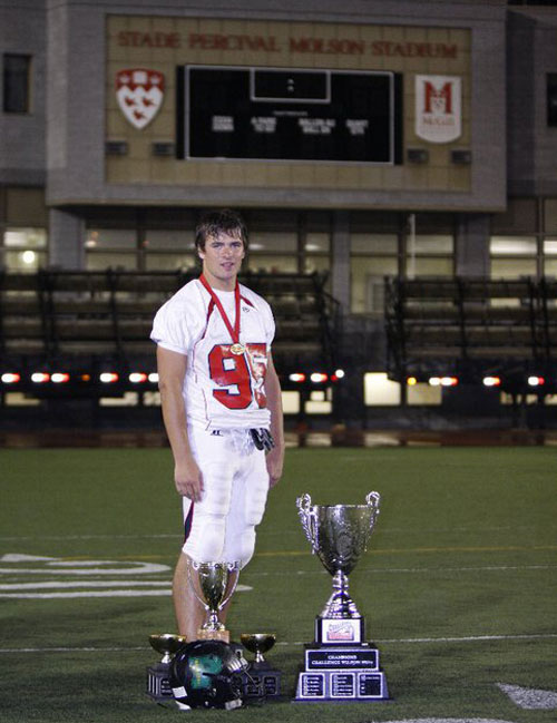 Raphaël Faucher avec les trophées sur le terrain de football.